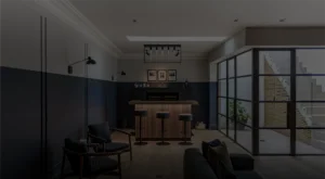 Modern home bar with wooden counter, black stools, and large glass doors leading to a staircase outside.