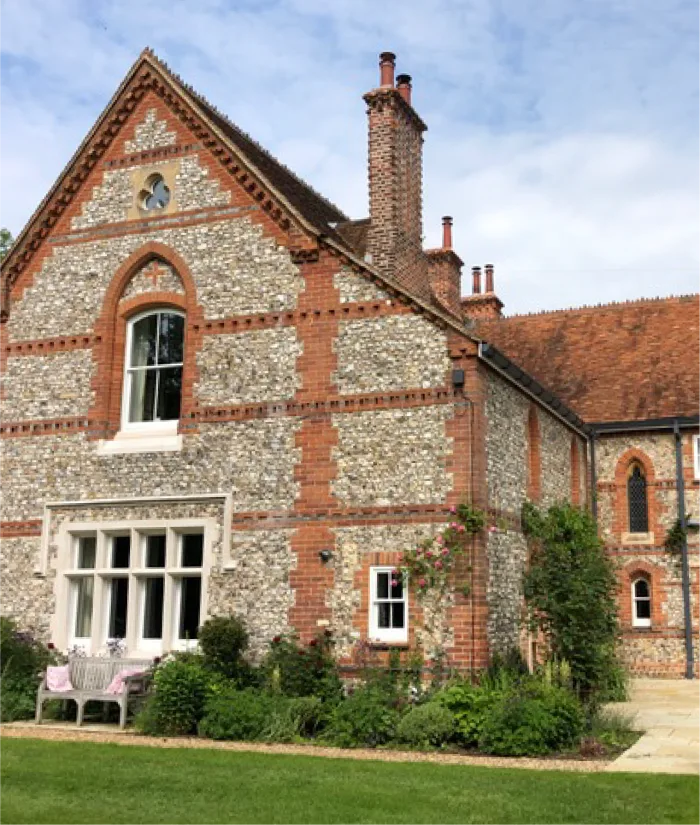 Charming historic brick and flint house with lush gardens and timeless architectural character.