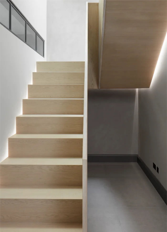 Modern wooden staircase with minimalist design and integrated lighting for a sleek, contemporary look.