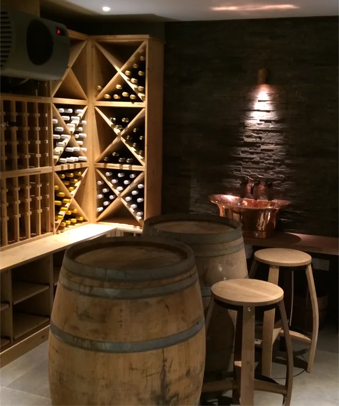 Rustic wine cellar with wooden barrels, wine racks, and a copper sink for a classic touch.