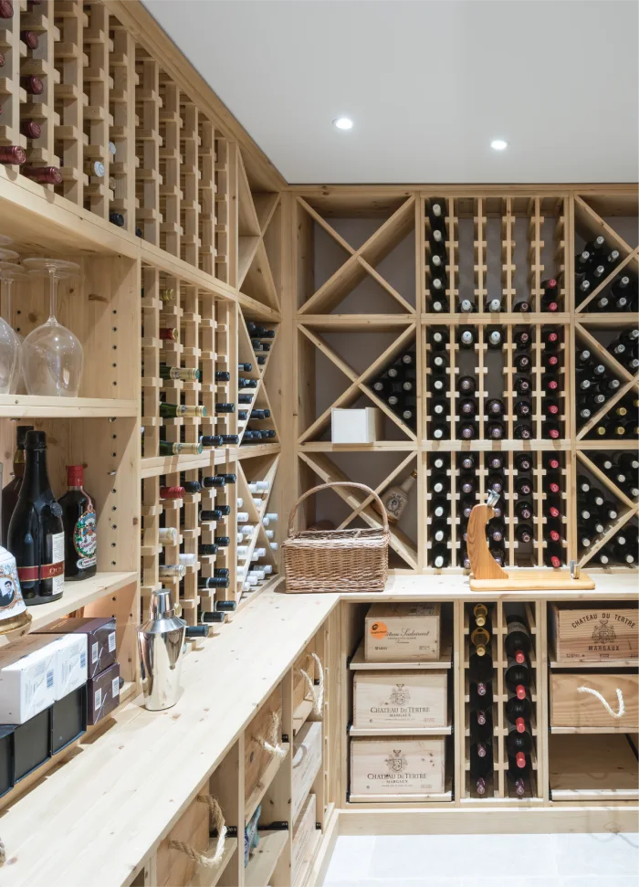 Elegant wooden wine cellar with organized racks and storage for bottles, crates, and wine accessories.