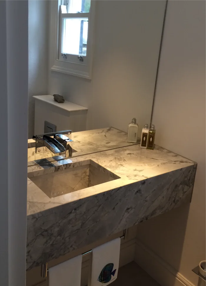 Elegant bathroom sink with a marble countertop and a built-in basin, complemented by chrome fixtures and decorative toiletries.